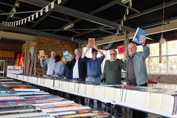 Rotarians holding up books at fair for web